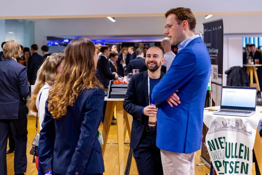 Een recruiter in gesprek met studenten bij haar statafel